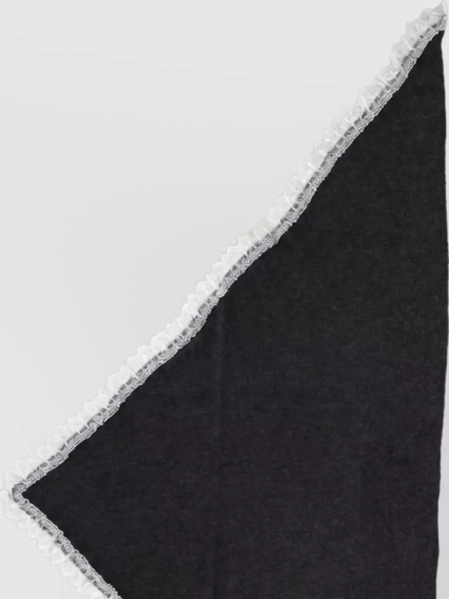 Ganni Merino wool openwork triangular scarf — The Ganni charcoal triangle kerchief with white lace trim subtly repeats the ruffle-and-lace theme at the neckline, tying together the black palette with a gentle romantic accent.