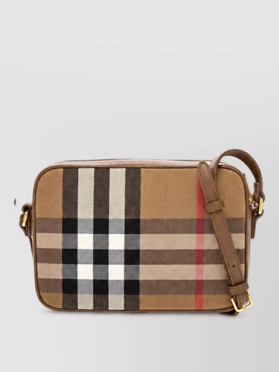 Burberry Leather clutch bag — The compact rectangular crossbody in check keeps the heritage story but its small scale prevents pattern overload next to the hoodie, while the hands-free shape matches the sporty energy.
