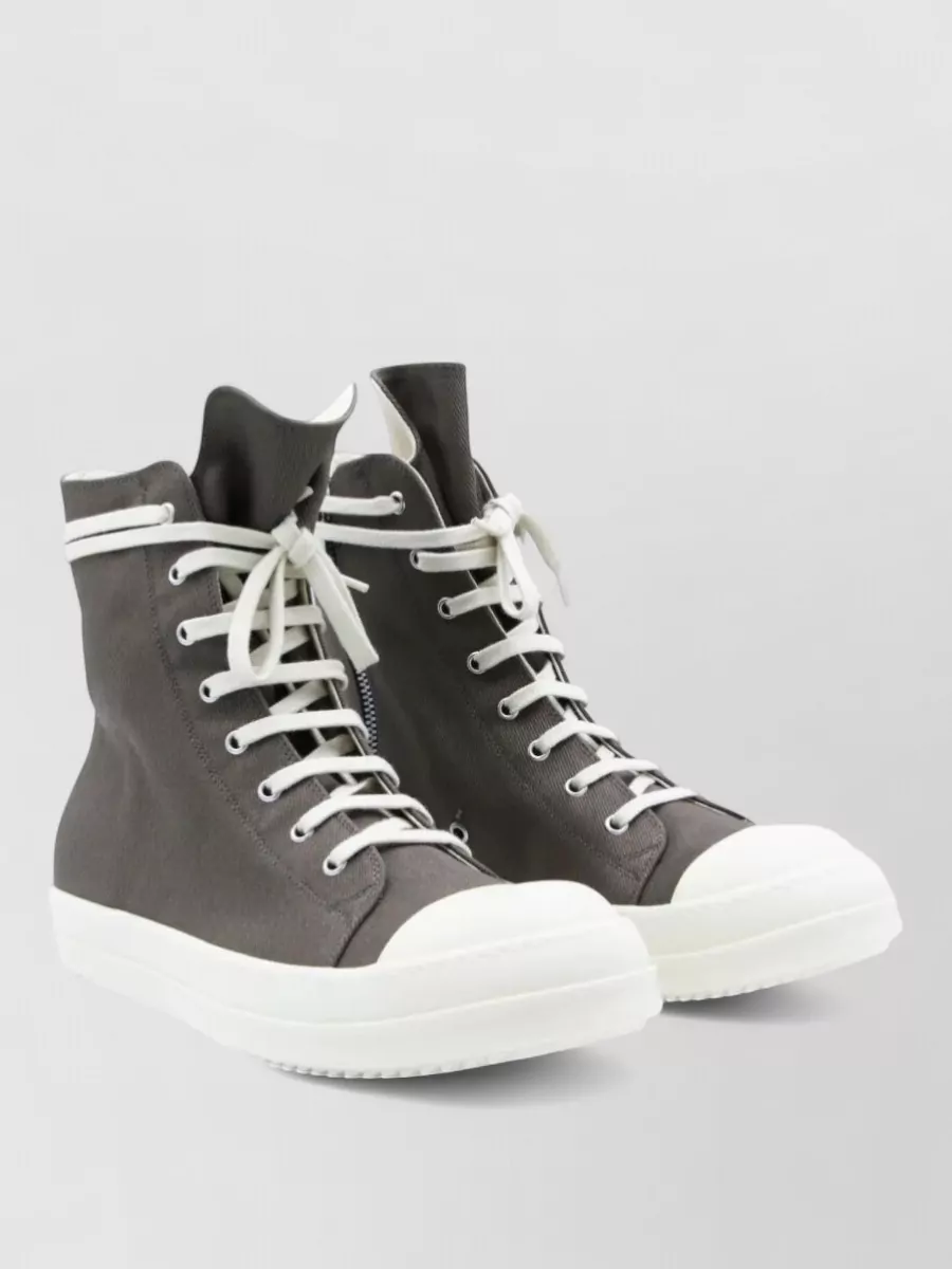 Rick Owens Drkshdw High-top sneakers — The charcoal hi-tops mirror the joggers’ washed tone and off-white drawstring, creating a continuous vertical line and classic Rick proportion with an exaggerated tongue and chunky sole.
