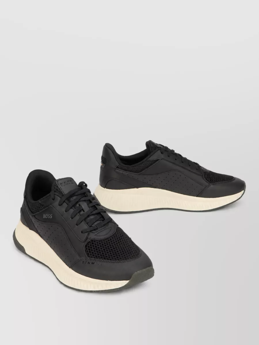 Boss Calfskin low-top sneakers — The black sneaker with cream sole and dark olive hits ties directly into the cargo’s tone while the black grounds the outfit and keeps the sport-minimal aesthetic polished.