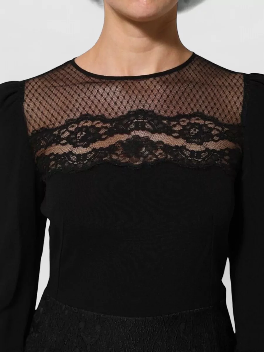 Dolce&Gabbana Floral lace knee-length dress — The black lace A-line dress has sheer yoke detail that echoes the thigh-highs’ romantic lingerie mood while giving a refined, cocktail-appropriate anchor for the outfit.