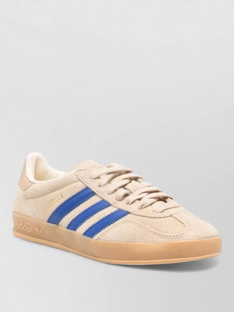Adidas Leather gazelle indoor low-top sneakers — The Adidas sand and blue skate-style sneakers ground the outfit in casual streetwear, pick up the denim blues, and keep the vibe practical and low-key for warm-weather days.