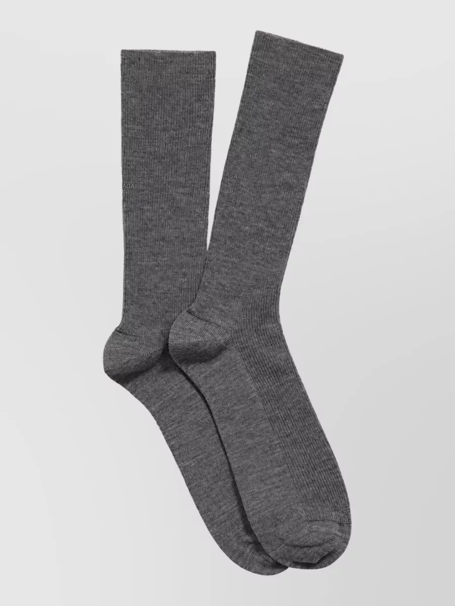 Balenciaga Ribbed wool socks — The white crew socks with black stripes continue the track motif between skirt and sneakers, creating a cohesive three-stripe story and a clean graphic break at the ankle.