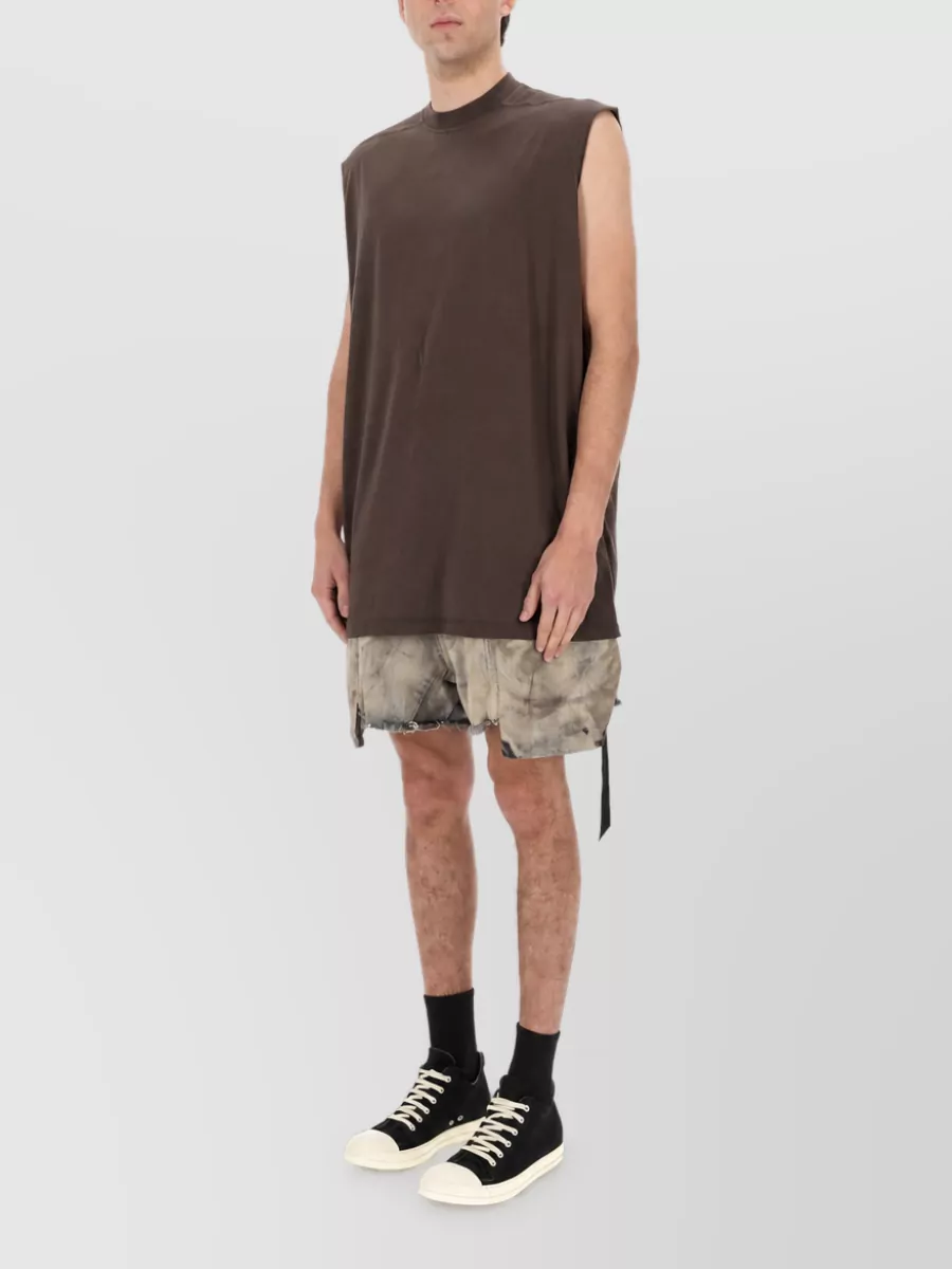 Rick Owens Cotton cargo shorts — The Rick Owens stone-taupe cargo shorts mirror the top’s taupe tone and relaxed, grungy streetwear attitude while keeping proportions long and loose under the elongated sleeveless tee.