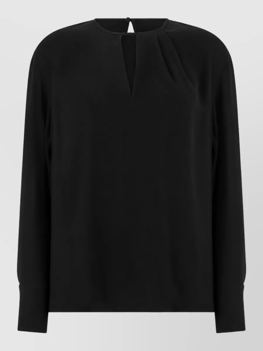 S Max Mara Silk blouse — The fluid black blouse keeps the suit column clean and tonal with the trousers, giving a sharp, elongated line that feels quietly luxurious from client meeting to dinner.