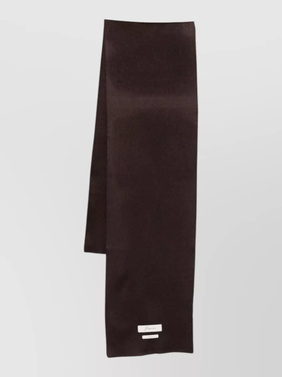 Jacquemus Cashmere scarf — The chocolate Jacquemus scarf adds a slim vertical line and subtle depth in the same tonal family, reinforcing the quiet, cocooned feel while keeping the styling minimal.