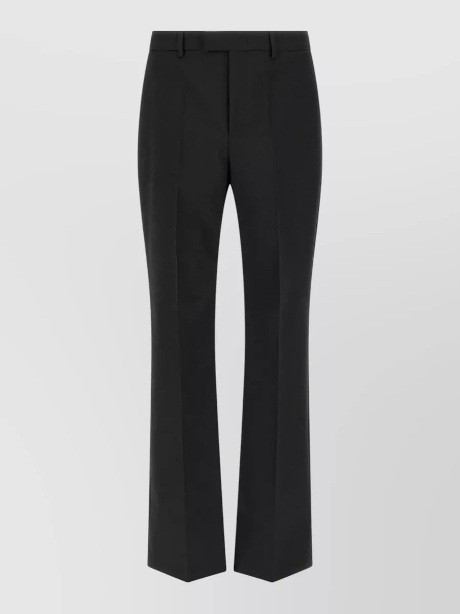 Valentino Garavani Virgin wool straight-leg tailored trousers — The sharp black tailored trouser mirrors the tee’s minimalist, quiet-luxury attitude and keeps the silhouette clean and refined rather than purely casual denim-based.