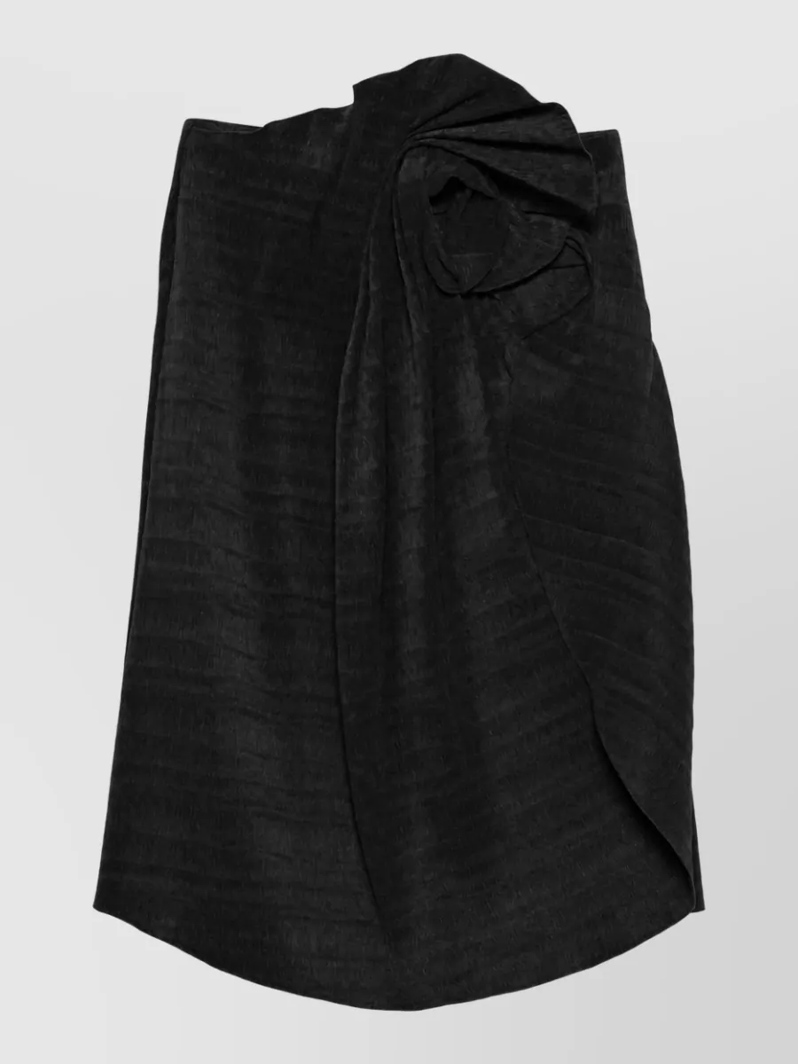 Magda Butrym Floral-knot skirt — The Magda Butrym strapless black column gown mirrors the romantic drama and formality of the Rene Caovilla spiral sandals while keeping the palette clean and allowing the crystal ankle detail to shine.