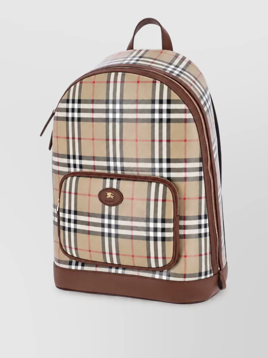 Burberry Backpack — Burberry’s beige and chocolate check backpack in H reinforces the brown tones of the knit and the sporty narrative, adding heritage pattern without clashing with the cleaner navy leg.