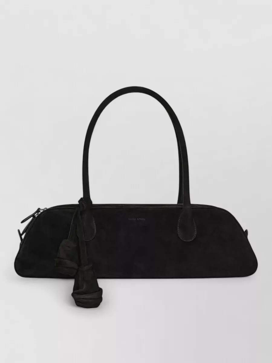 Magda Butrym Na shoulder bag — Lemaire’s deep charcoal-brown crescent bag harmonises with the earthy taupes in the outfit and adds a softly architectural counterpoint to the coat’s sharp vertical lines.