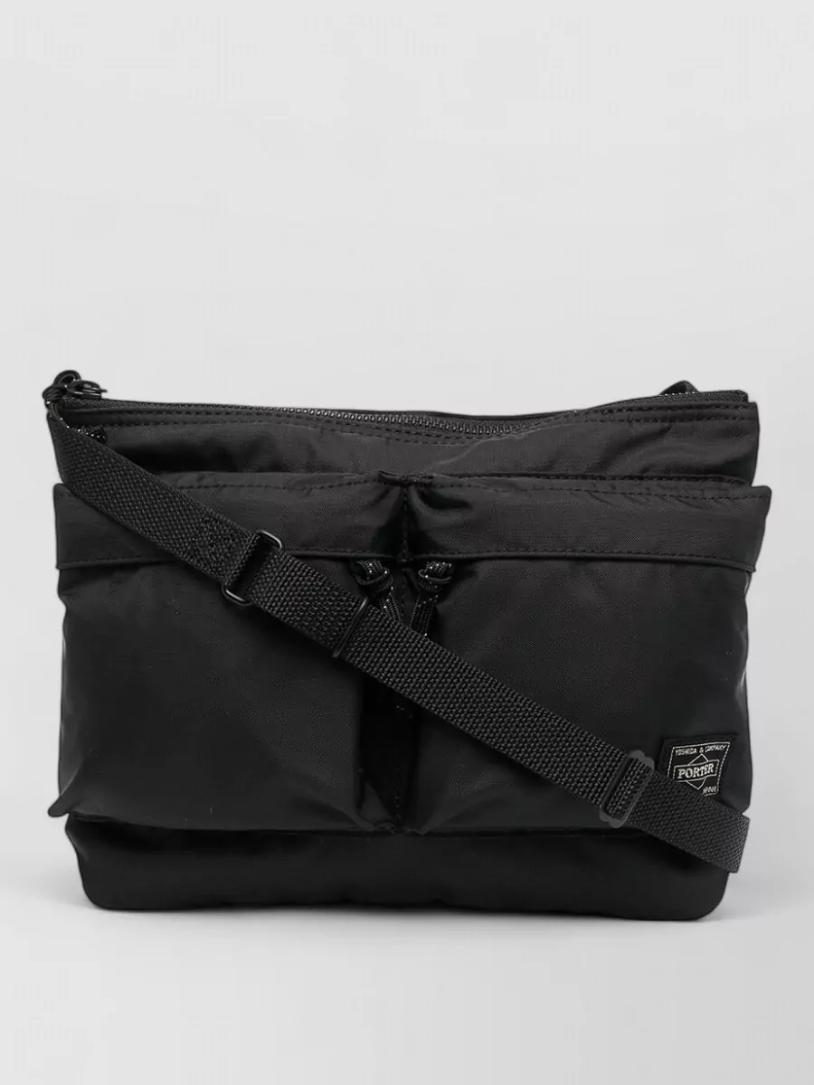 Porter Force nylon shoulder bag — The compact black Porter crossbody keeps to the technical, minimalist palette and sits cleanly against the oversized tee and shorts without adding bulk to the already relaxed silhouette.