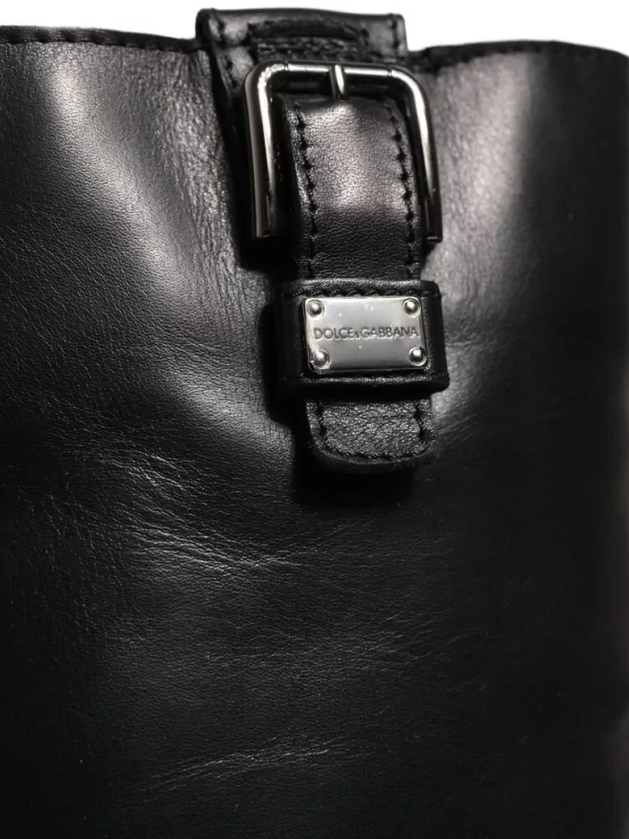 Dolce&Gabbana Leather mid-calf boots — The Dolce&Gabbana knee-high chunky-sole boot in smooth black leather echoes the jacket’s hardware, adds grounded utility, and visually balances the long knit column without tipping into overt glamour.