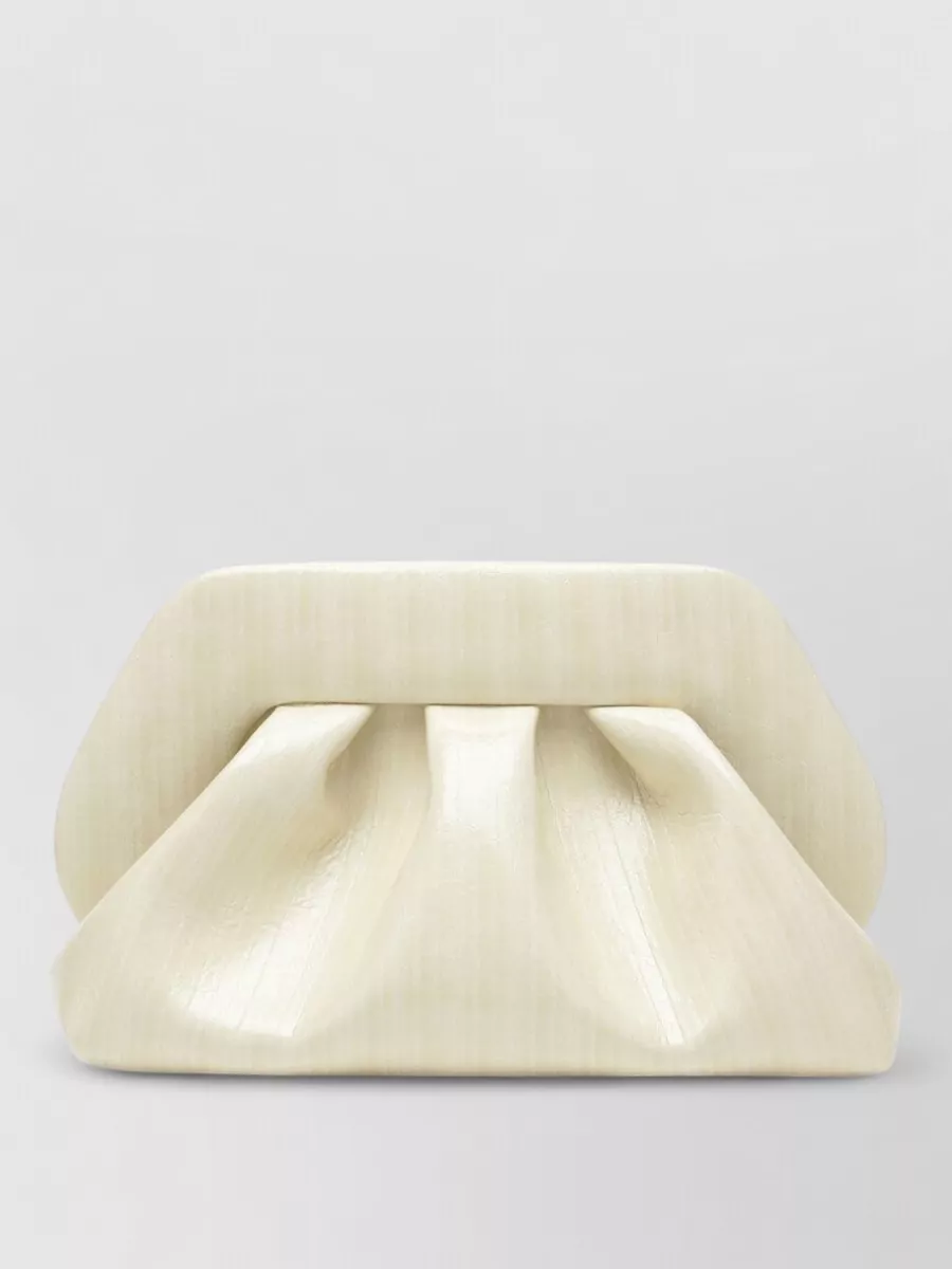 Themoiré Na clutch bag — The buttercream pleated clutch adds sculptural structure and a neutral, softly luminous note that harmonises with the champagne top and metallic shoes without adding extra color or fuss.