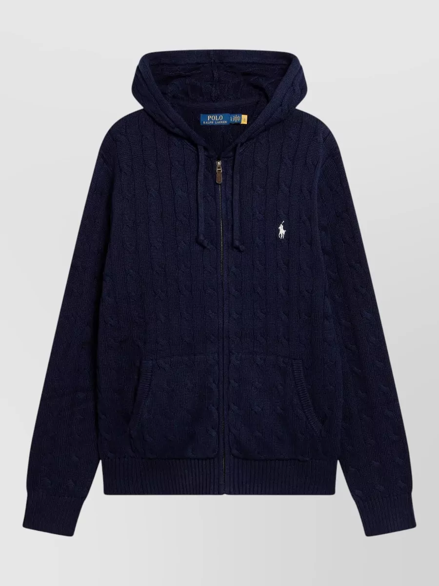 Polo Ralph Lauren Hoodie — The navy cable-knit zip hoodie adds texture and a slightly smarter preppy note under the glossy puffer while keeping the palette tonal and aligned with Ralph Lauren’s sport-prep mood.
