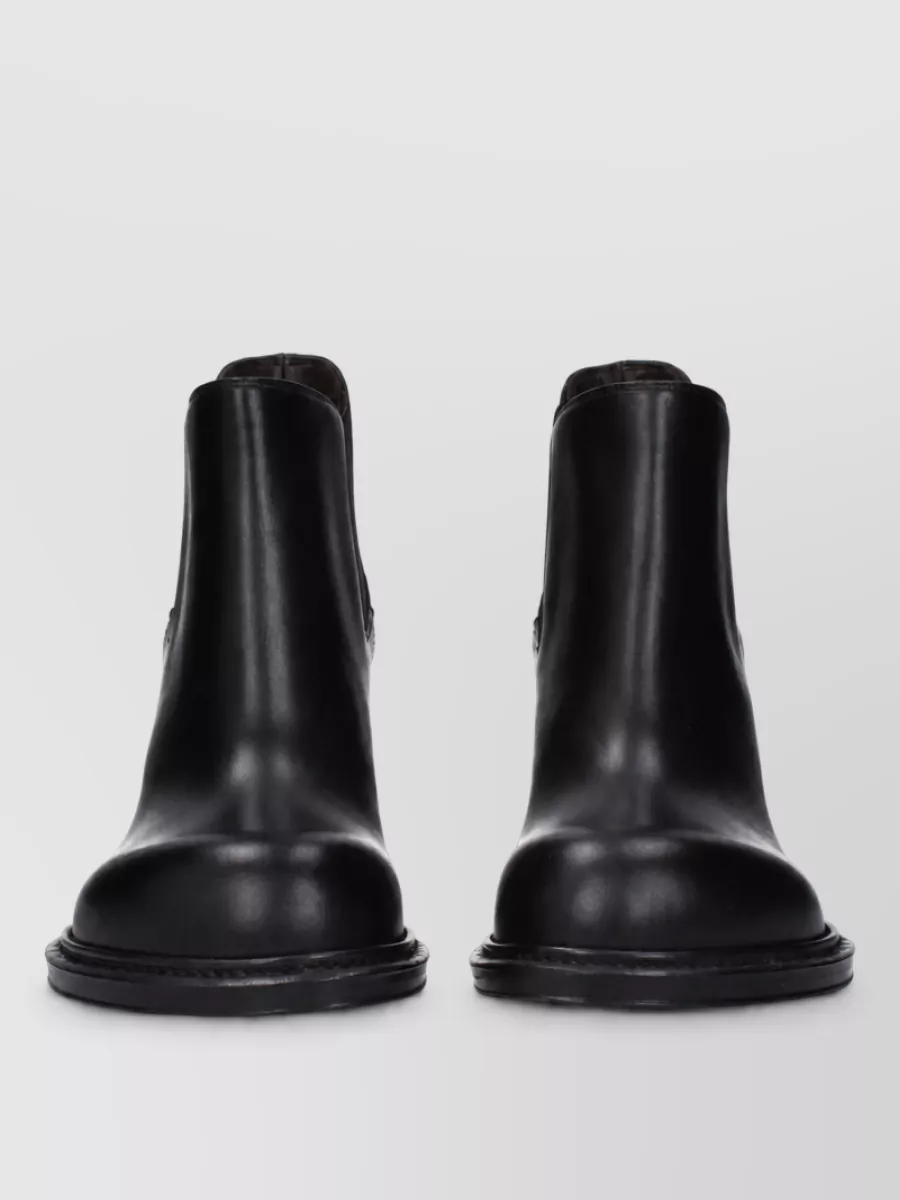 Bottega Veneta Leather lace-up ankle boots — The Bottega ankle boots have an understated block heel and clean toe that ground the slim trouser and turtleneck with polished quiet luxury rather than overt hardware.
