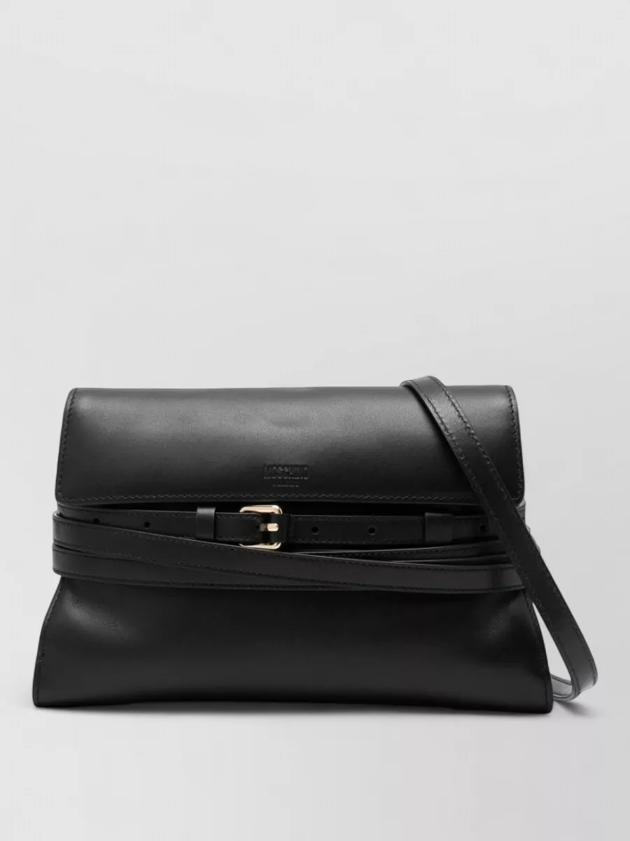 Moschino Leather clutch bag — The elongated structured Moschino bag in black with silver hardware mirrors the clean, architectural mood of the outfit without adding visual noise to the statement skirt.