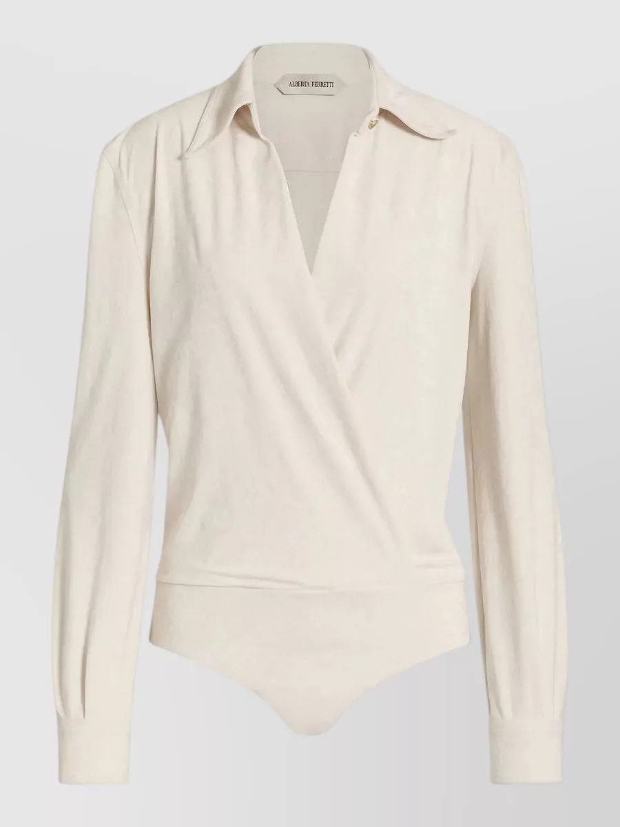 Alberta Ferretti Draped v-neck wrap bodysuit — The ivory wrap-front bodysuit keeps the waist clean, balances the high-waisted black trouser and aligns with the minimalist quiet-luxury brief while staying polished for office-to-dinner dressing.