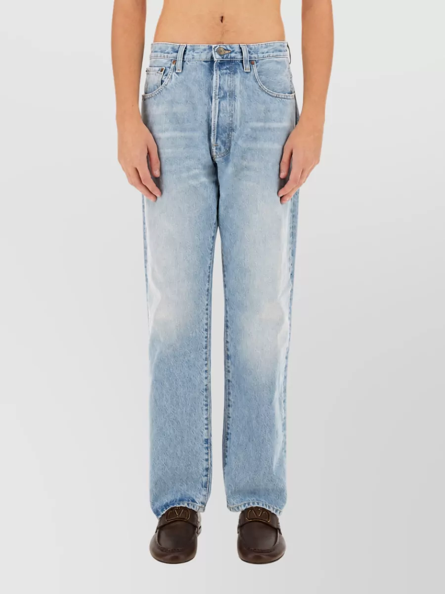 Valentino Denim jeans — The light-wash straight-leg denim matches the tee’s minimalist streetwear energy, keeps the formality casual, and balances the bold black logo with a fresh summer blue.