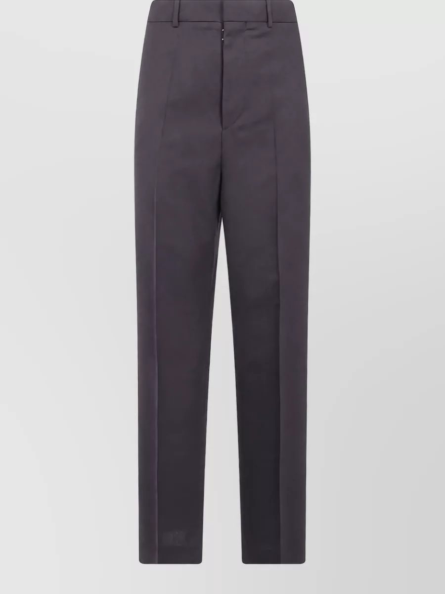 Maison Margiela Wool tailored trousers — The deep charcoal tailored trouser matches the coat’s sharp, mid-length line and dressy tone, creating a cohesive column of dark tailoring that feels modern yet restrained.