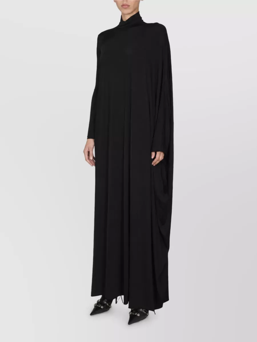 Balenciaga Maxi dress — The draped black column dress mirrors the trench’s elongated, minimalist line and formality, creating a coherent evening story without competing tailoring layers.
