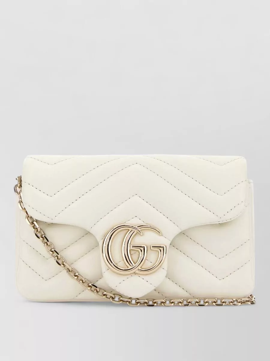 Gucci gg marmont mini leather shoulder bag — The ivory quilted Gucci shoulder bag echoes the gilet’s texture and color while staying compact and refined, completing a tonal black-and-ivory story with consistent brand tier and minimal hardware.