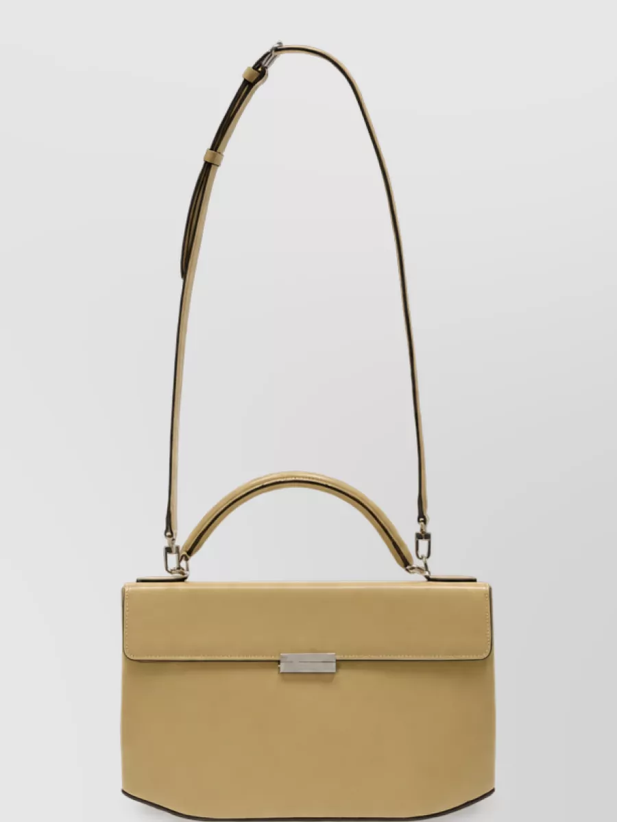 Totême Leather top handle shoulder bag — The butter-toned structured shoulder bag sits in the same soft beige family as the trousers, adding quiet structure and polish while keeping the outfit resolutely tonal.