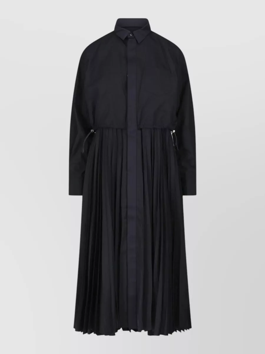 Sacai Knee-length midi dress — The black Sacai shirt dress mirrors the outerwear’s hybrid tailoring and creates a clean, column base that layers elegantly under the relaxed double‑breasted knit blazer.