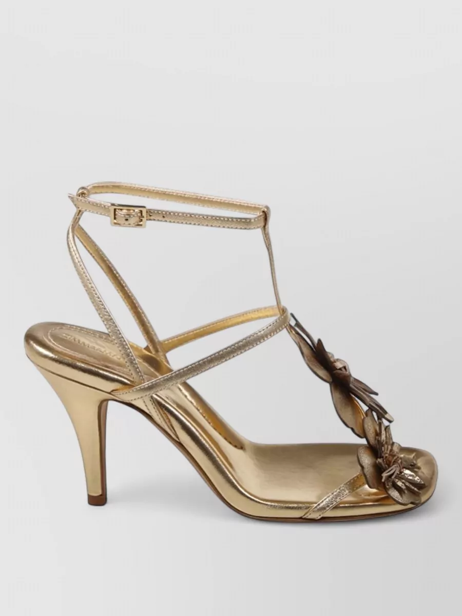 Zimmermann Leather floral appliqué high-heel sandals — The Valentino black strappy stilettos echo the dress’s sculpted waist, match the charcoal elements in the print, and give cocktail-level polish without competing with the floral pattern.