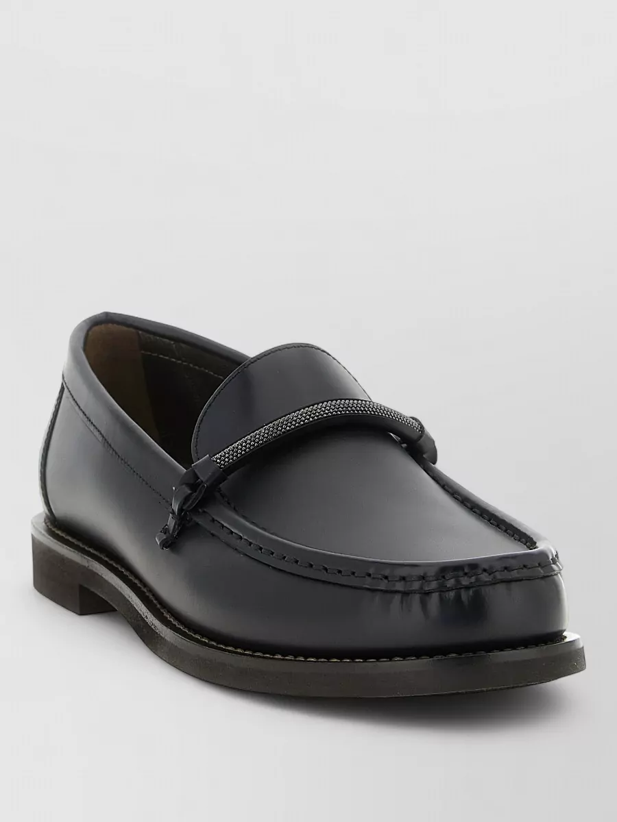 Brunello Cucinelli Leather penny loafers — The ink navy almond-toe loafers are formal enough for tailoring, structurally complement the wide leg, and add a subtle depth that still reads neutral with charcoal and ivory.