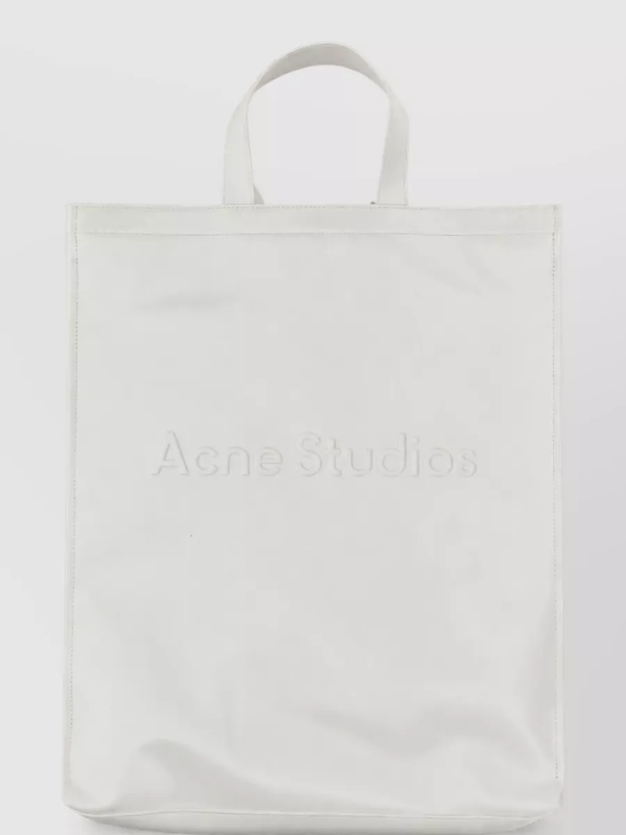 Acne Studios Logo tote bag — The taupe-and-tan Margiela shoulder bag ties into the cream base with a slightly utilitarian edge, aligning brand-wise with the tee and keeping the palette soft and quiet.