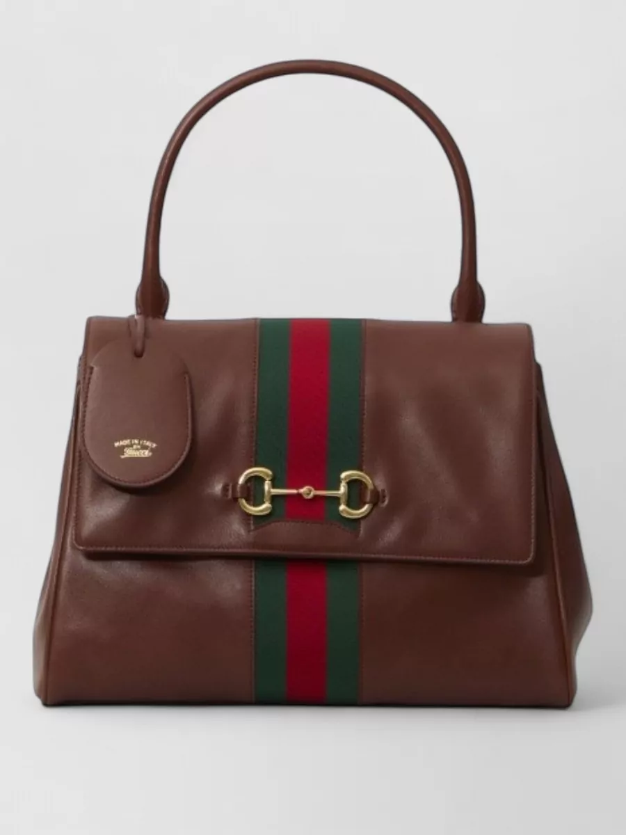 Gucci Medium calfskin shoulder bag — The structured chocolate top-handle with web detail brings rich brown contrast, matches the shoe accents, and feels suitably polished for a luxury, work-to-dinner skirt pairing.