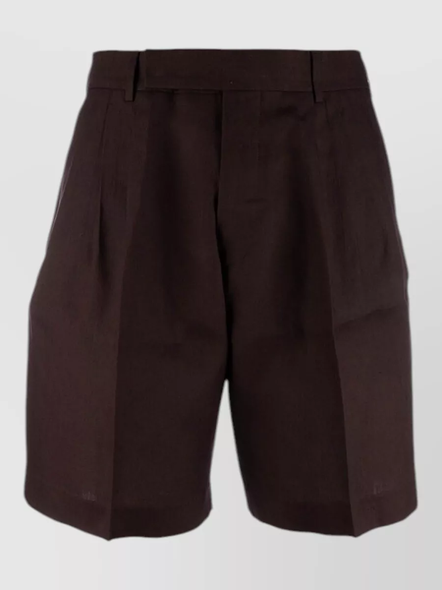 Paul Smith Linen tailored shorts — The Paul Smith dark chocolate pleated shorts ground the shirt’s painterly print with a solid, refined base that matches the price tier and keeps the pattern mix from feeling chaotic.