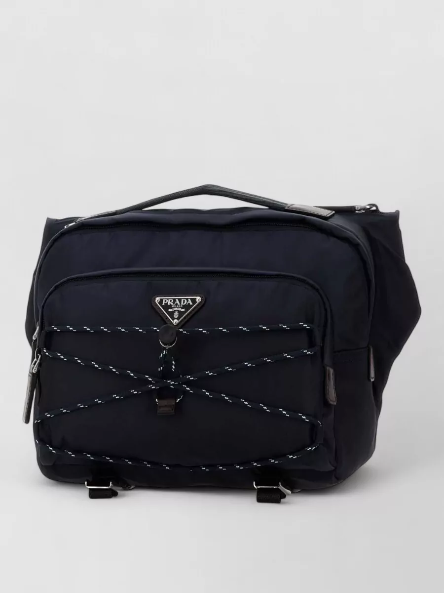 Prada Re-nylon belt bag — The sleek black Prada crossbody supports the technical street-sport mood, matches the dark hardware story, and stays compact so the suspenders and pant detailing remain the focus.