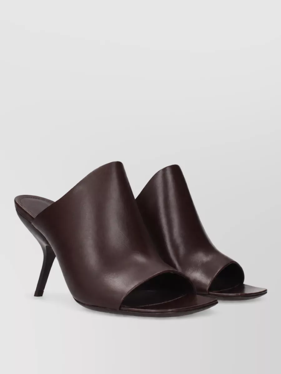 Ferragamo Leather mules — Ferragamo’s chocolate open toe mules echo the trouser color while adding refined height and a quietly sensual line that suits the high waisted wide leg for polished work to dinner dressing.