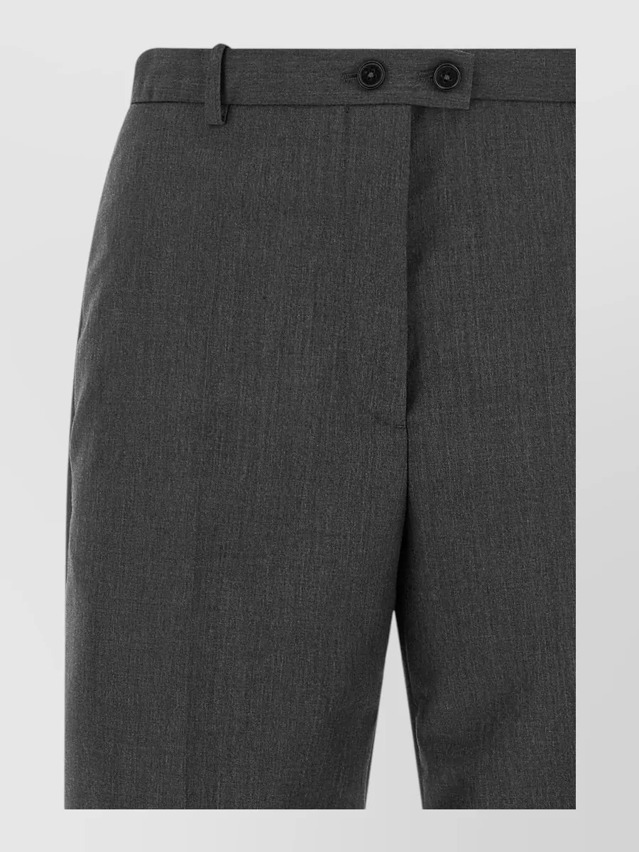 Jil Sander Tailored trousers — The Jil Sander straight-leg trouser mirrors the blazer’s minimalist, tailored quiet-luxury mood and charcoal palette, giving a clean elongated line that aligns perfectly with the sharp shoulders and nipped waist.