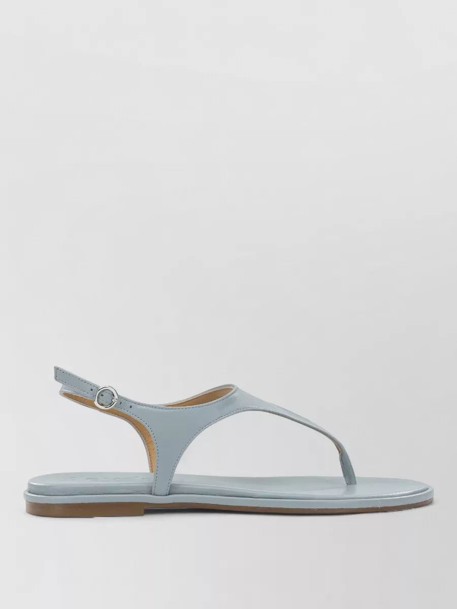 Aeyde Leather slides — The pale blue Aeyde thong sandals keep the outfit minimal and airy while precisely echoing the short’s blue tones for a refined, head-to-toe color story.