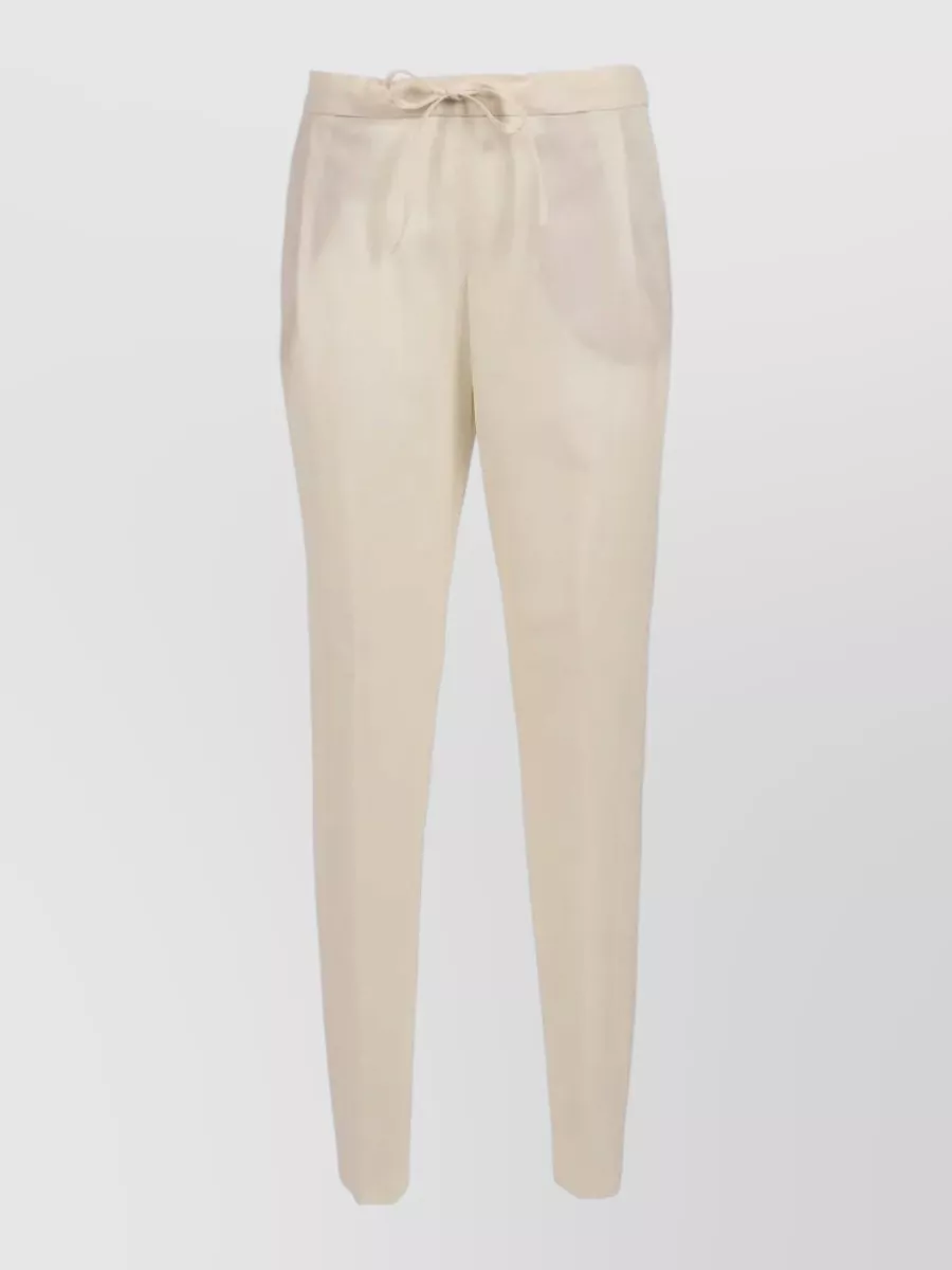 Fabiana Filippi Tapered trousers — The relaxed straight-leg ivory drawstring trouser mirrors the shirt’s minimalist utility mood and soft volume, giving a light, SS-friendly contrast to the olive while keeping the overall polish at the same tier.