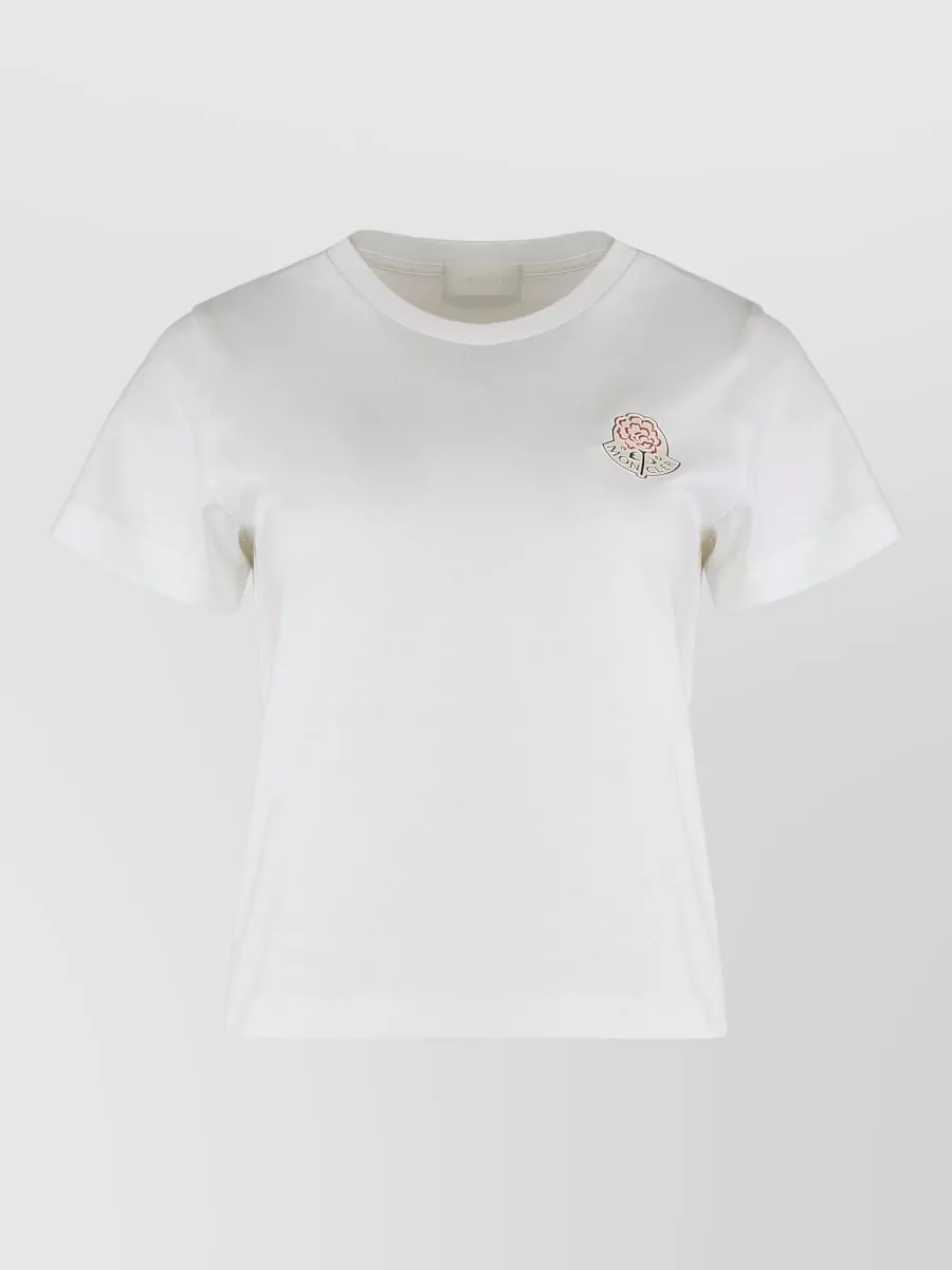 Moncler Cotton crew neck short-sleeve t-shirt — The navy, camel and cream striped polo directly echoes the short’s camel tone and sporty tailoring, creating a cohesive preppy-sport mood that matches the relaxed formality and season.