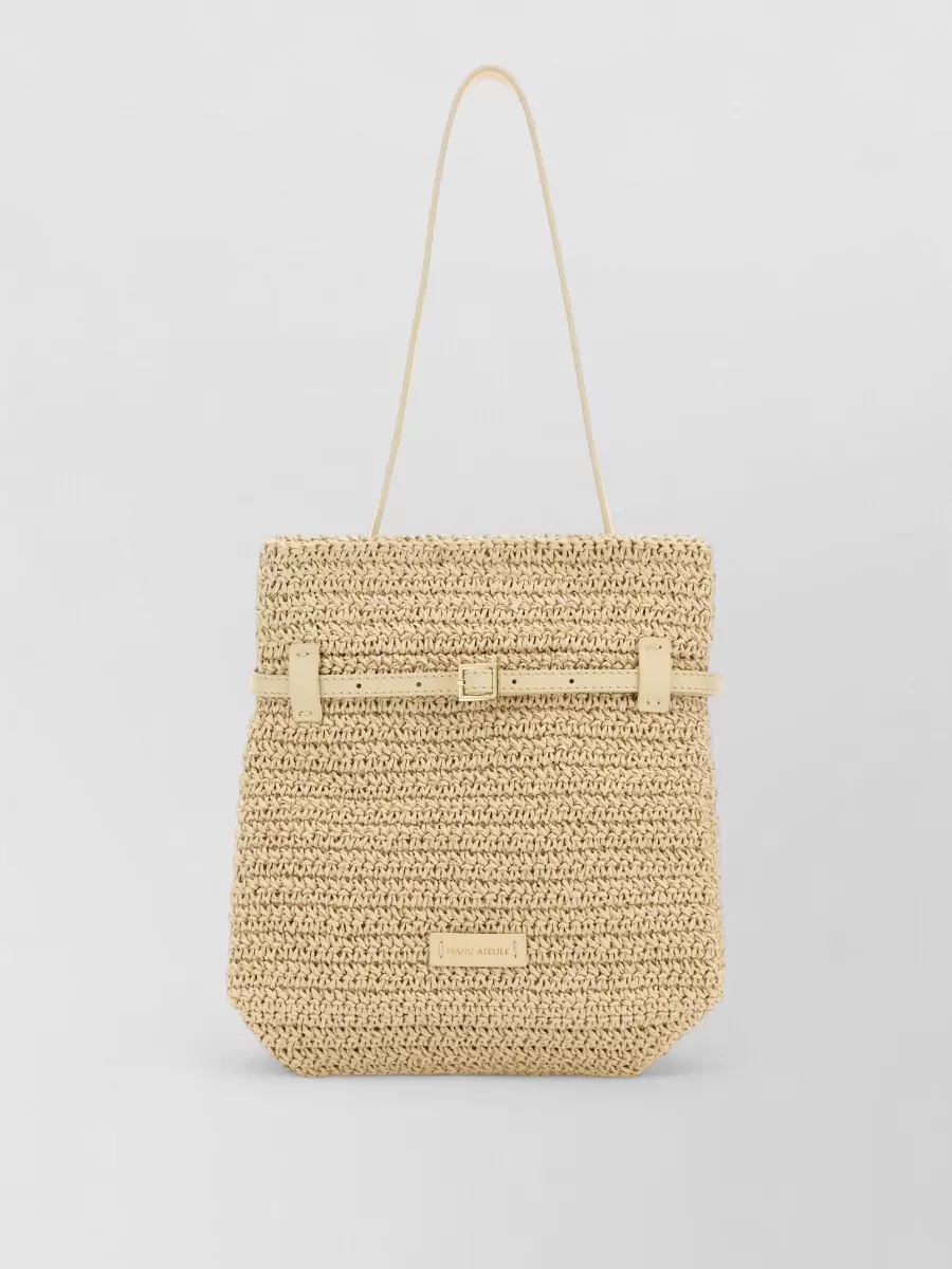 Manu Atelier Mini raffia beach bag — The Manu Atelier raffia tote reinforces the beach-to-city story, ties into the warm sand tones of the dress, and matches the sandal’s relaxed sport-luxury feel without overpowering it.