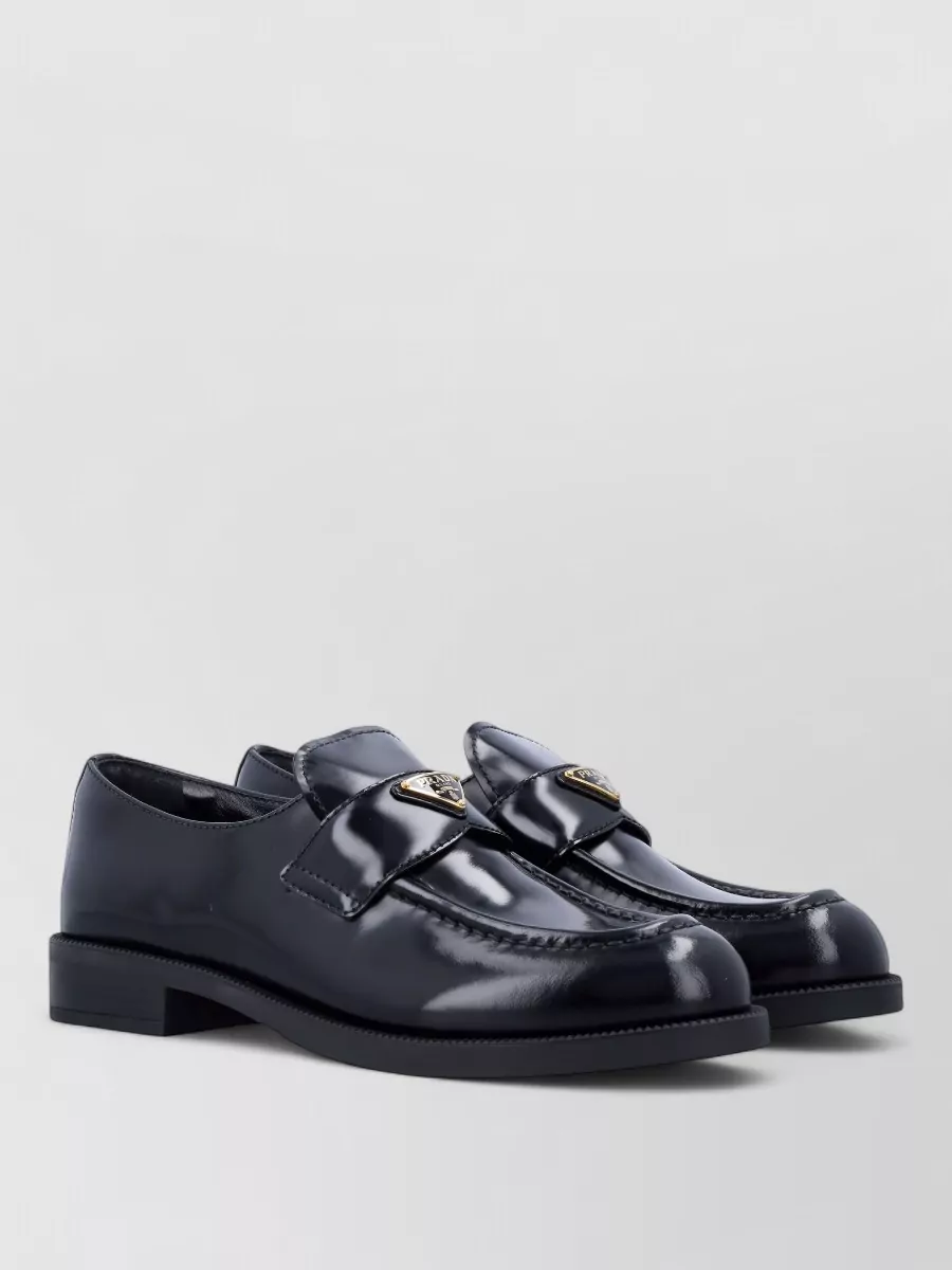 Prada Leather loafers — Prada’s sleek navy low-heel loafers harmonise with the deep navy pants and keep the outfit smart yet low-key, aligning with the quiet luxury aesthetic while remaining comfortable for city days.
