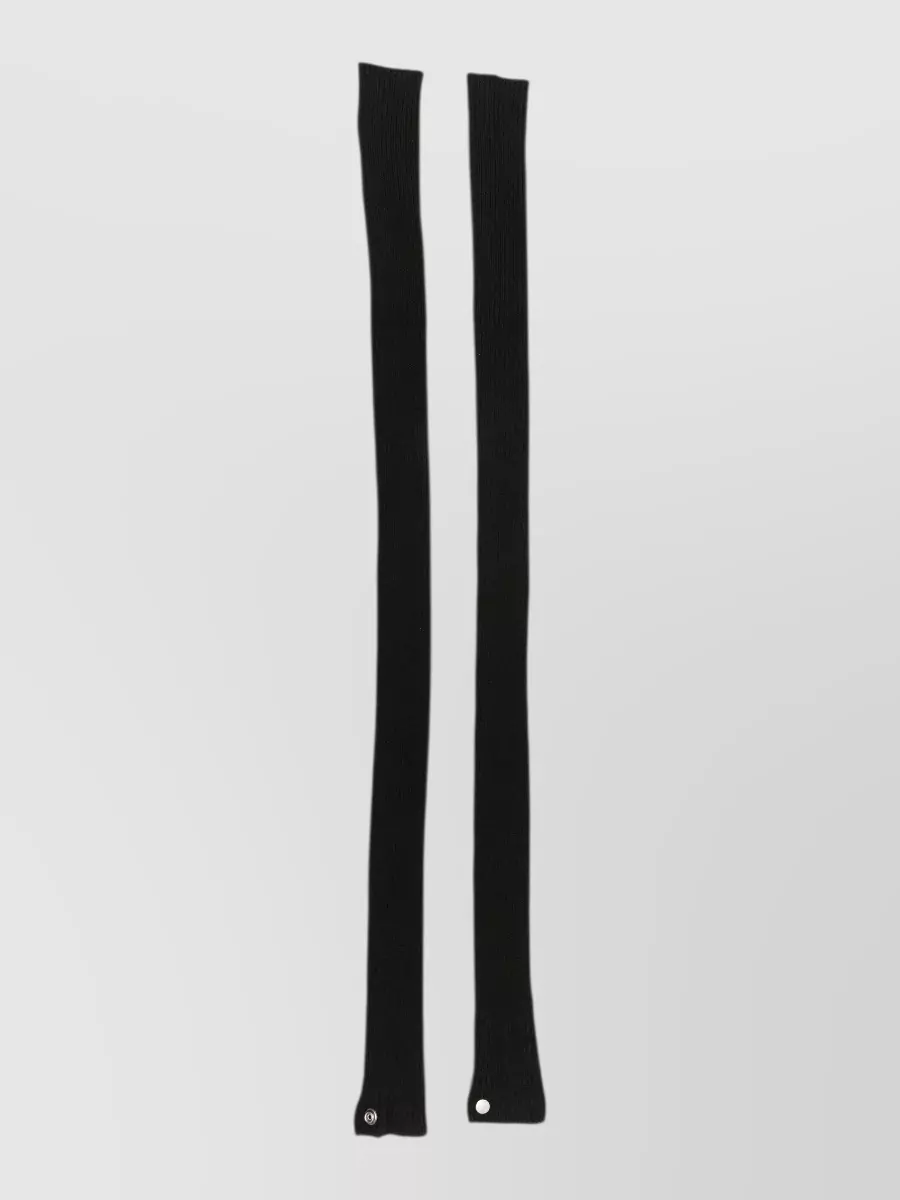 Rick Owens Wool arm warmers — The ultra-long black Rick scarf extends the vertical lines of the outfit, snapping and draping into the same directional, dystopian mood as the tee and pants.