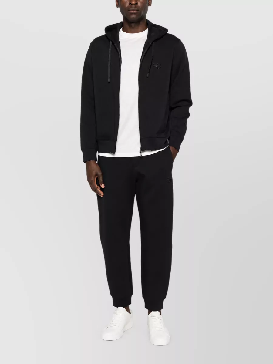 Emporio Armani Logo cotton track pants — The black tapered track pants keep the outfit firmly in the minimalist sport-street space, and the clean cuffed leg balances the tee’s regular fit without adding unnecessary formality.