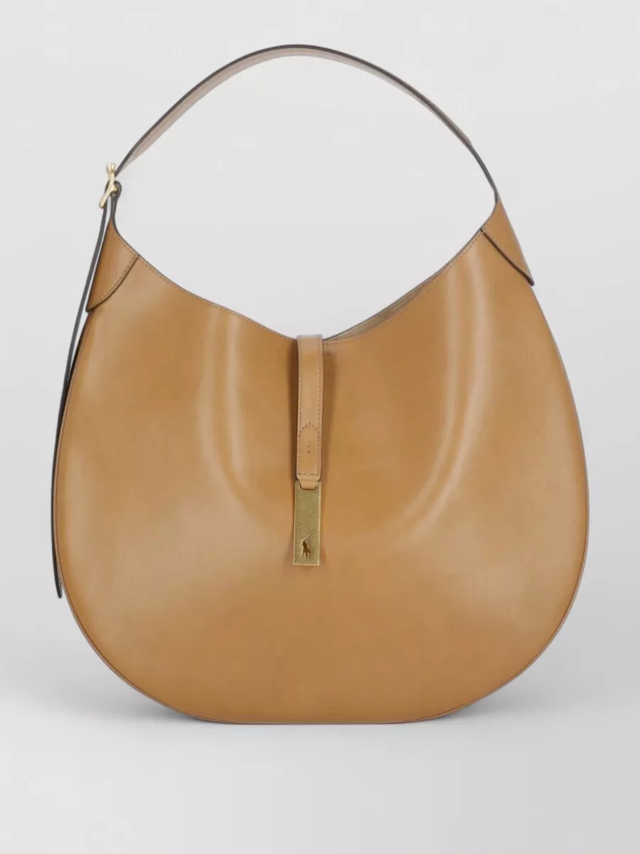 Ralph Lauren Leather shoulder bag — The tan Ralph Lauren hobo echoes the warm beige trouser and dark shoe, keeping the palette coherent and the overall effect relaxed yet refined rather than overly corporate.