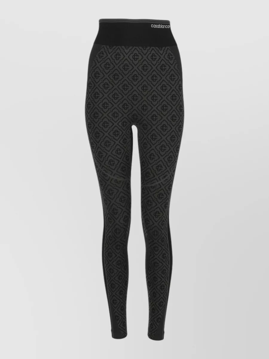Casablanca Slim-fit leggings — The tonal black Casablanca jacquard legging keeps the palette tight with the white tank while leaning fully into a minimalist, quiet-sport mood in the same brand and price tier.