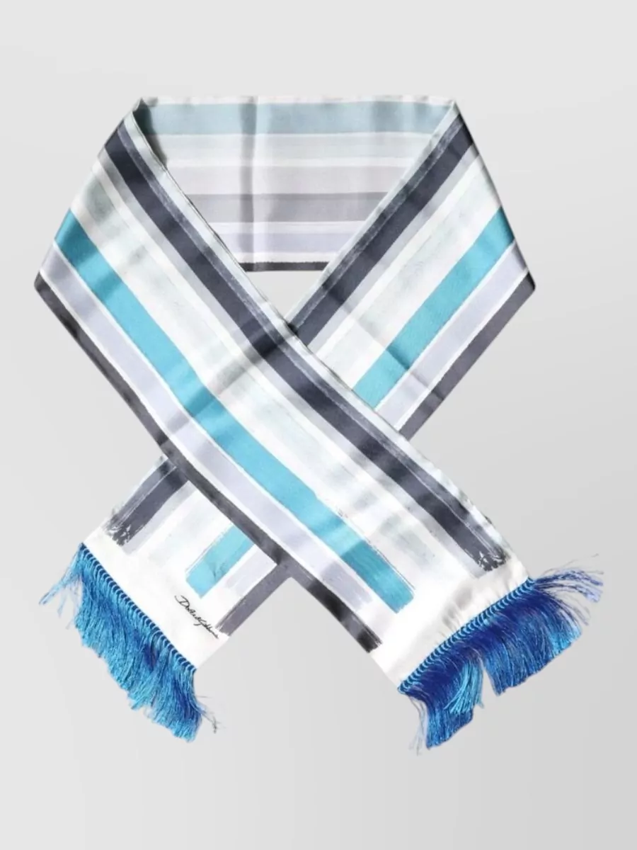 Dolce&Gabbana Silk striped fringe scarf — The turquoise striped scarf echoes the tee’s blue, introduces charcoal accents to tie in the trims and sneakers, and adds a light graphic layer without bulk.