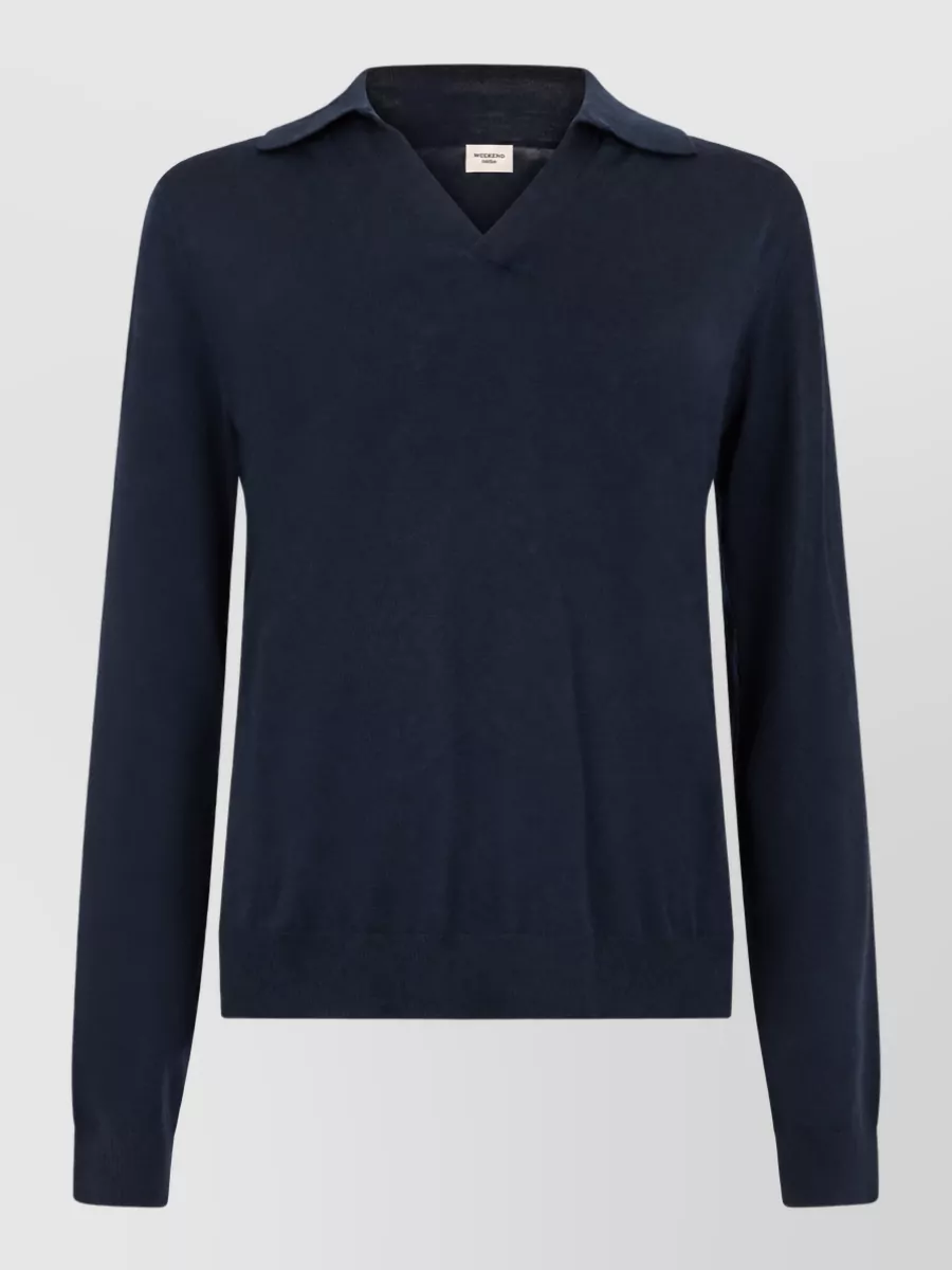 Weekend Max Mara Cashmere wool long-sleeve collared sweater — The navy collared V-neck knit mirrors the jacket’s preppy, minimalist mood and Weekend Max Mara branding, creating a clean tonal column that layers smoothly without competing with the hooded outerwear.