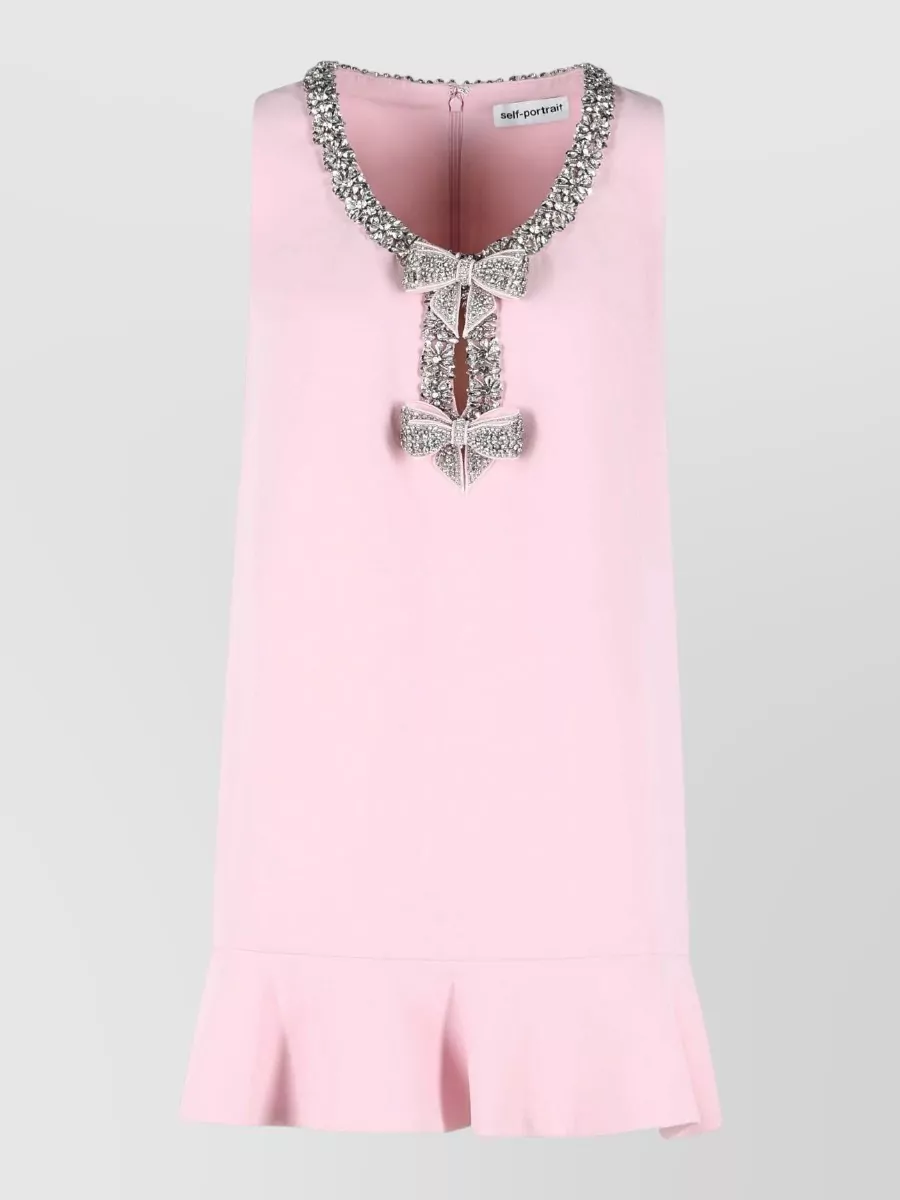 Self-Portrait Polyester mini dress — The sleeveless blush embellished shift mirrors the jacket’s soft pink tweed, crystal neckline and bow hardware almost exactly, creating a refined twinset effect that feels intentional and couture-lite.