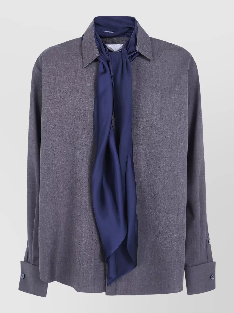 Sacai Tailored suit jacket — The slate-grey shirt with navy scarf detail is tailored, quietly subversive and slim enough to sit cleanly under the structured Sacai coat while echoing its inky accents.