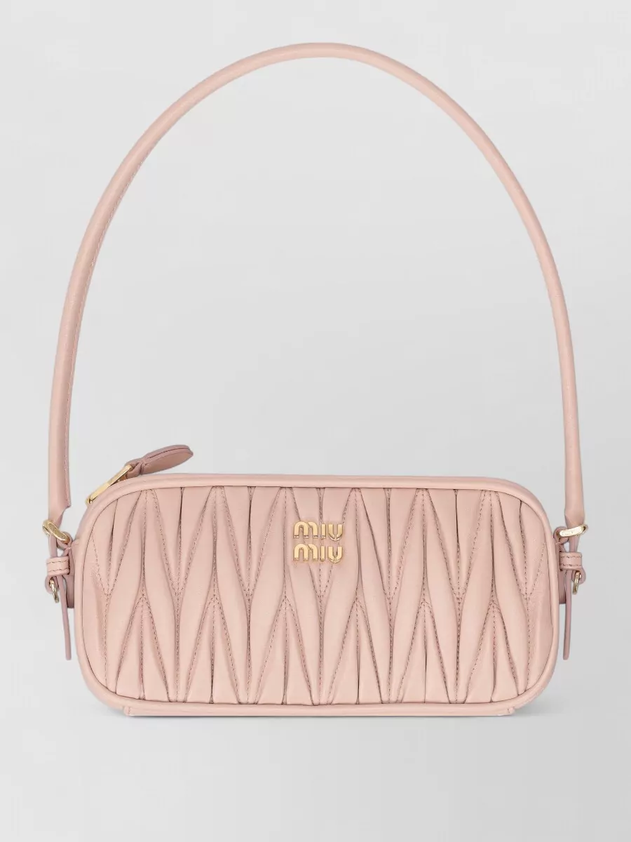Miu Miu Adjustable-strap leather clutch bag — The Miu Miu blush baguette harmonises with the pink palette, keeps the vibe romantic and youthful, and avoids black heaviness so the focus stays on the dress and embellished slingbacks.