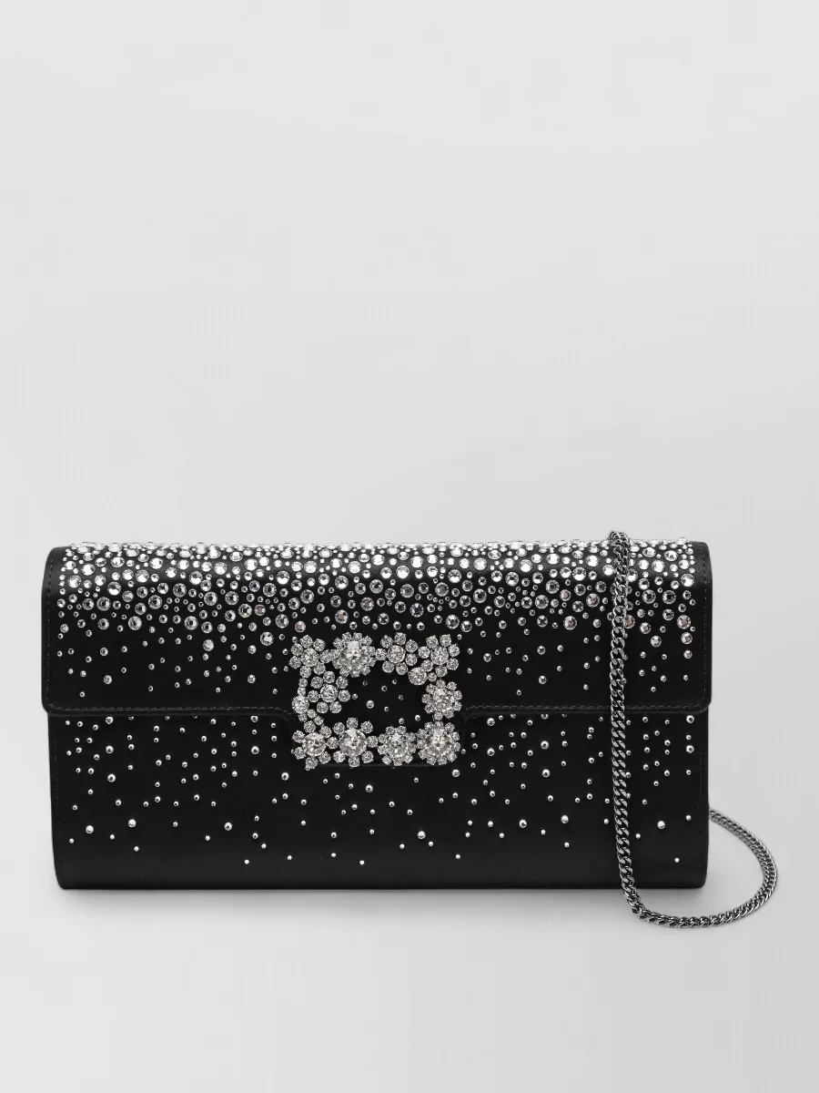 Roger Vivier Clutch bag — The Roger Vivier black satin clutch with graduated crystals and floral buckle harmonizes with the pumps and skirt, giving a focused black-and-silver evening story that feels richly couture.